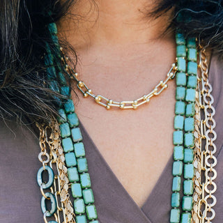 Gold Horseshoe Chain Necklace on Woman Layered with Turquoise and Gold