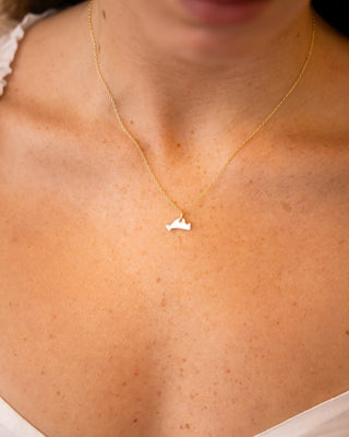 gold chain with a tiny marthas vineyard island shaped pendant on a womans neck