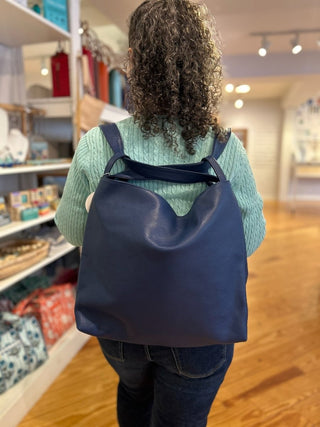 Person wearing a blue leather 
backpack in a store setting