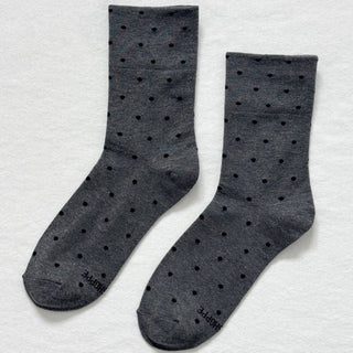 Pair of gray socks with black polka dots on a light gray background Le Bon Shoppe
