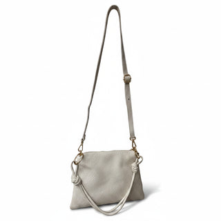 White leather handbag with a strap on a white background