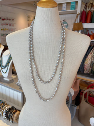Mannequin head with a long silver freshwater pearl necklace in a store setting
