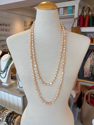 Mannequin bust with a pink freshwater pearl knotted necklace in a store setting