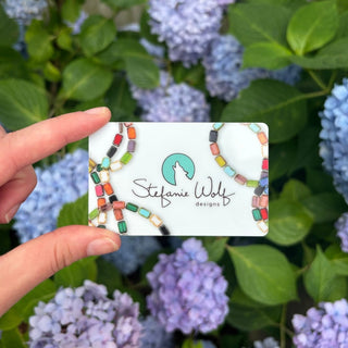 Stefanie Wolf Designs Marthas vineyard jewelry gift card in front of hydrangeas in hand