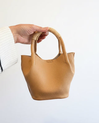 Tan Top Handle Vegan Leather Bag in hand on white background