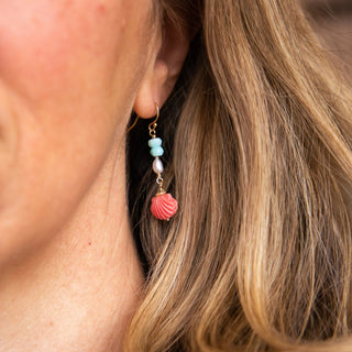 Coral pink scallop shell drop earrings with Blue Peruvian opal and freshwater pearl on gold on womans ear