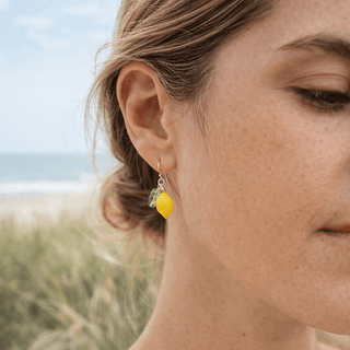 14k gold fill handmade lemon fruit earrings on model at the beach 