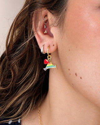 Close-up of an ear with rainbow Martha's Vineyard and heart hoop earring.