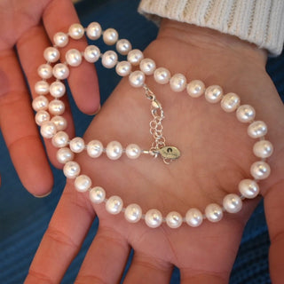 White freshwater pearl necklace in hands